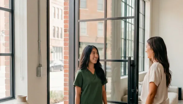 Two women meeting at a doorway