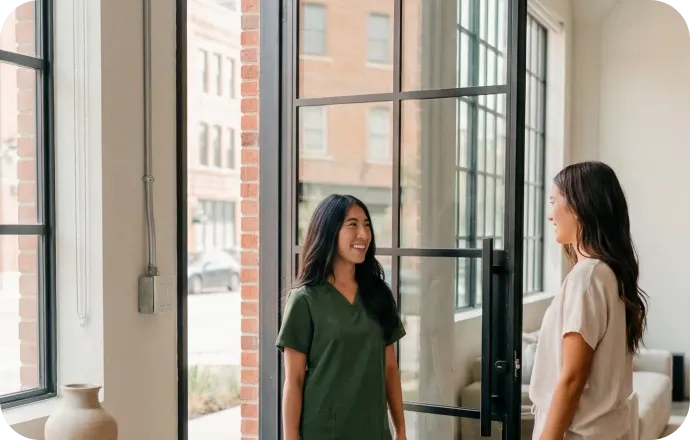 Two women meeting at a doorway