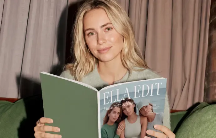 A woman reading a magazine on a green sofa